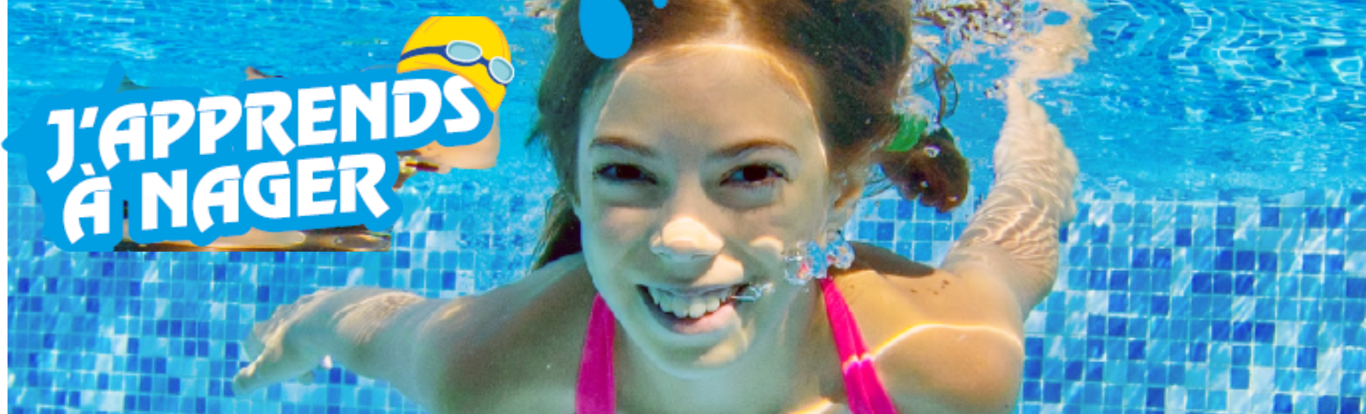 une enfant qui fait un sourire sous l'eau