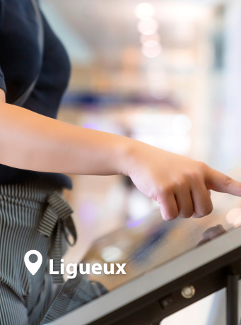 Une main en train d'utiliser une borne numérique