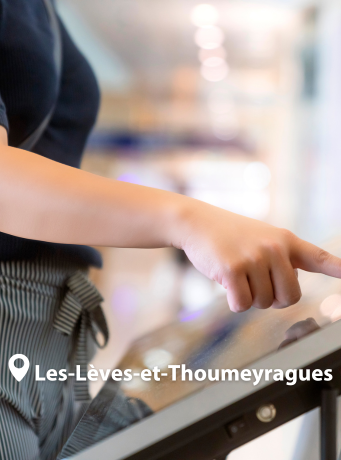 Une main en train d'utiliser une borne numérique