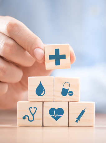 main qui fait une construction avec cube ayant un symbole en lien avec la santé